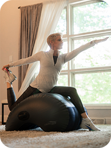 Woman using the AeroTrainer for support while she performs a yoga pose