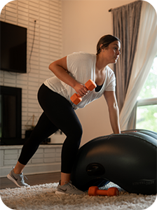 Woman using the AeroTrainer for support while she performs a dumbbell row